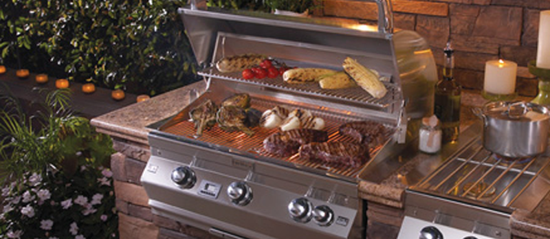 Meat and vegetables being grilled on the grill in one of our premium modern outdoor kitchens